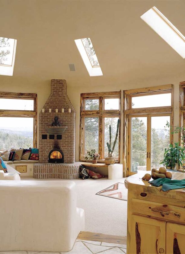 Skylights are designed and configured so that winter sun pours through and heats the south-facing adobe walls and bancos. As the home cools off in the evening, heat is drawn back out. The living area’s circular shape stems from Tom and Flame’s previous living quarters: a tipi. Rough-cut slabs of wood frame each window, creating a textural relief to the smooth plaster walls and adding depth of field to the panoramic room. This gives the house a sense of the profound. “When you look at nature, nothing’s flat; the eye has to constantly focus and refocus,” Tom says. “In our house, all these different surfaces fade into each other, and the eye catches a lot of movement because of that depth. That has a lot to do with why people come in and say, 'Wow, this feels so amazing.’”